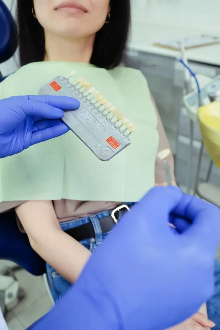 Dentist performing shade colour consultation with a patient at a smile design clinic in Antalya, Turkey
