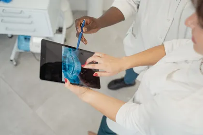 Dentist and patient reviewing dental scans and treatment planning documents together at a specialist clinic in Antalya