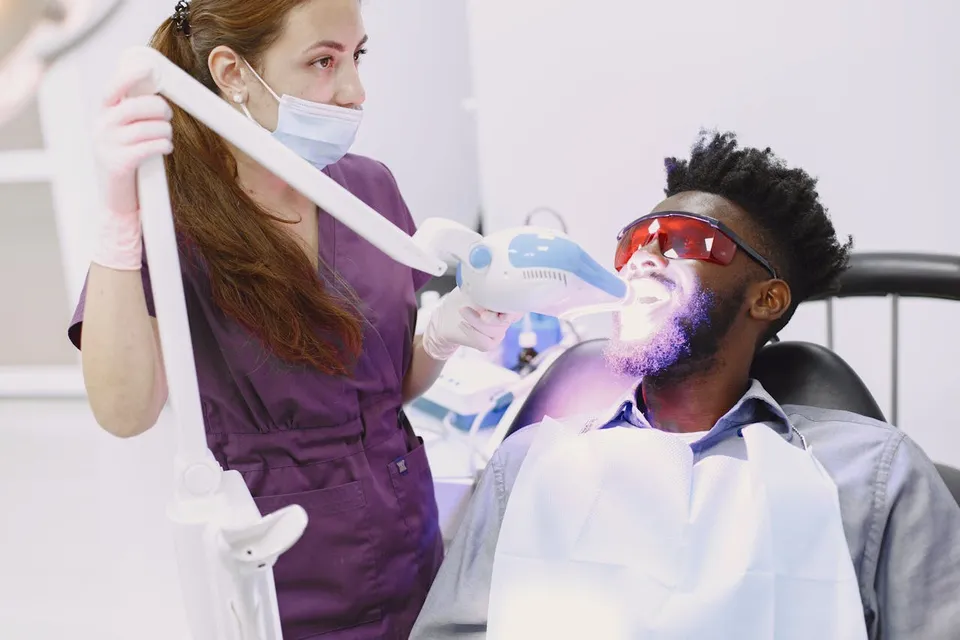 Professional teeth whitening UV light procedure being performed at a dental clinic in Antalya, Turkey